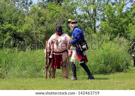 TORONTO - JUNE 15: Pathfinder and soldier at reenactment of the conflict of Revolutionary War between refugees and Loyalists at  Black Creek -  in June 15 2013 in Black Creek Village, Toronto, Canada