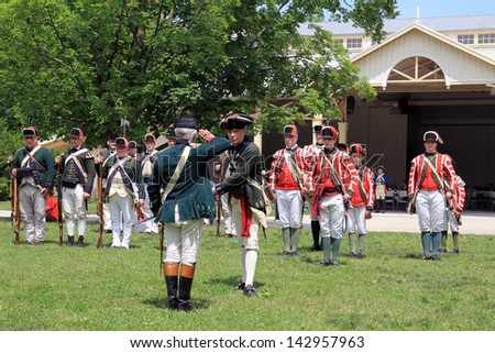 TORONTO-Â?Â? JUNE 15: Military parade at reenactment of the conflict of Revolutionary War between refugees and Loyalists at  Black Creek -  in June 15 2013 in Black Creek Village, Toronto, Canada