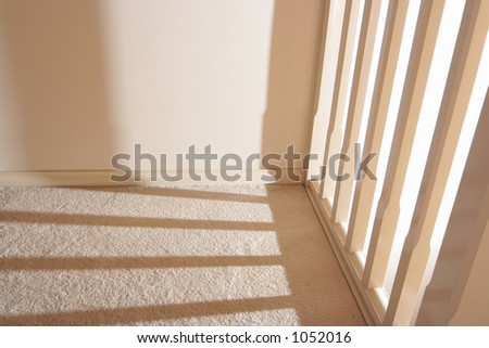 Stairway columns casting a shadow on a corridor