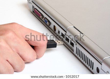 A usb cable being plugged in to a notebook
