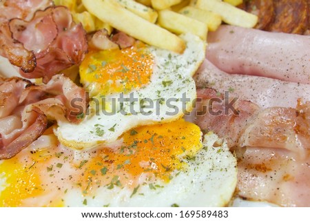 English breakfast - chips, egg, bacon, ham and sausages