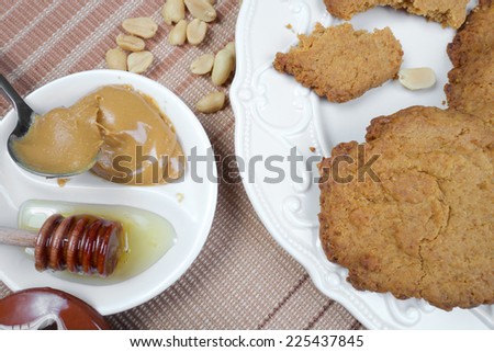 Sweet healthy peanut cookies on wooden table with honey