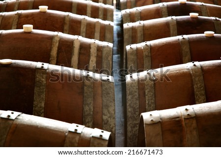 Wine barrels and wine casks in a winery cellar full of vats and storage areas owned by wine makers in various wine regions