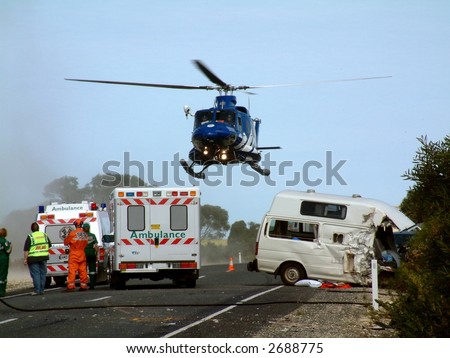 A helicopter lifts off, with patient on board at road crash scene