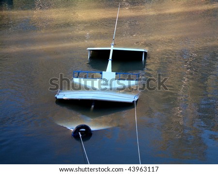 Sunken river boat. A great bad luck or disaster theme shot for marine or any unfortunate event. This sinking boat was for sale at the time?