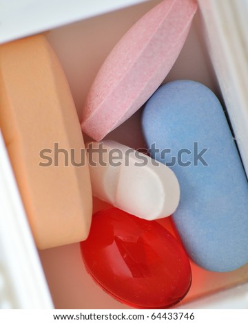 An assortment of pills in a weekly pill container.