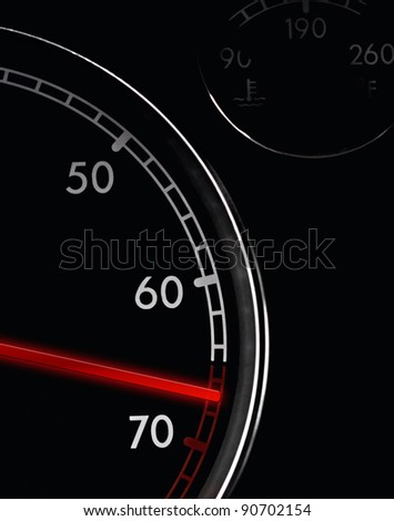 Car tachometer, dash board close up, red arrow in a red zone