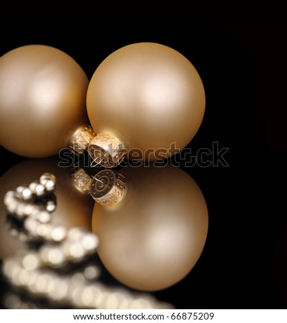 gold christmas baubles on a reflective black background