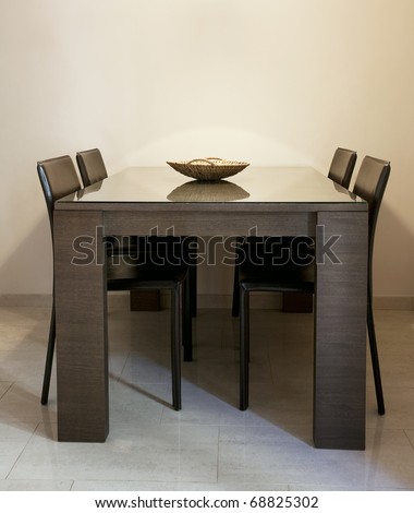 Modern dining room with brown chairs and a table with glass coating