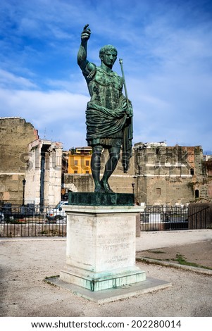 Rome, Italy. Ancient statue of Octavian Augustus (Ancient Rome first emperor) in front the remains Forum of Caesar.
