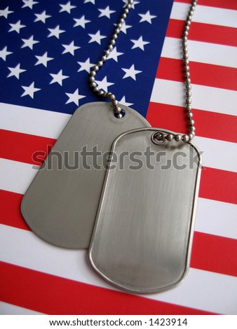 Dog tags and the flag of America. Focused on the dog tags.