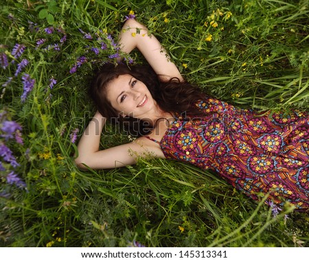 Beautiful girl relaxing lying on the grass. Beauty Model Woman Face with freckles.