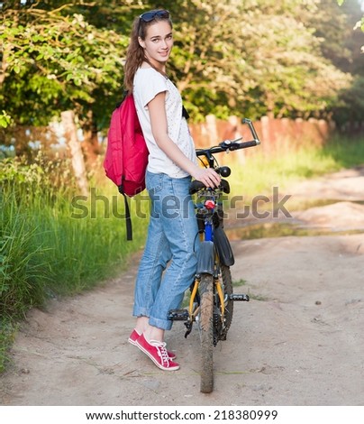 Young beautiful slim woman outdoors portrait with bike