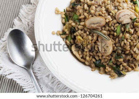 Healthy vegan barley dish with mushrooms collard greens, thyme and rosemary.
