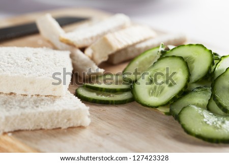 White bread with crust cut off and cucumbers to make cucumber sandwiches for afternoon tea