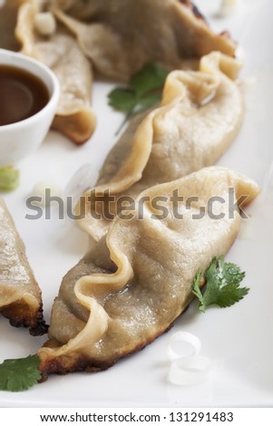 Pot stickers appetizer with orange soy sauce.