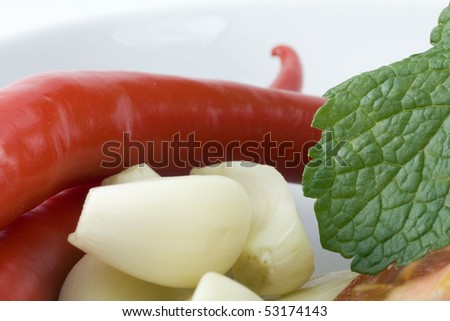 Garlic cloves with mint leaves and hot peppers
