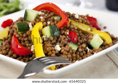 Close up of lentil salad with bell peppers and cucumber.