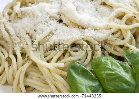 Gourmet pesto pasta dinner with fresh basil leaves.