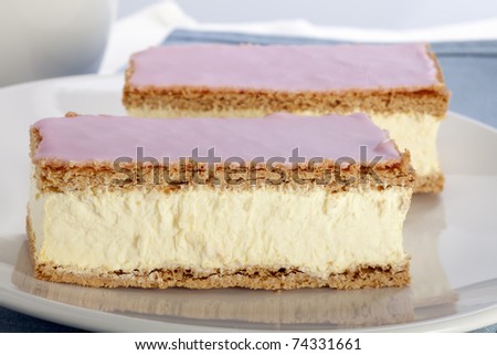 Tompouce, a common pastry  in the Netherlands and Belgium made  with puff pastry , filled with sweet yellow pastry cream and topped with pink icing.