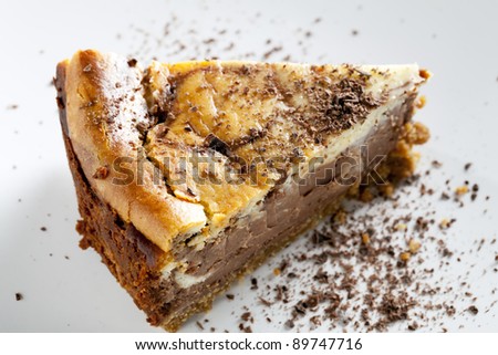 Slice of chocolate cheesecake sprinkled with chocolate flakes.