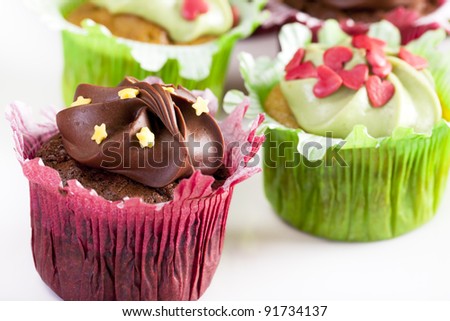 Chocolate and vanilla cupcakes in red and green cupcake wrappers topped with candies.