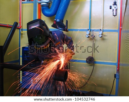 worker grinding pipe before weld