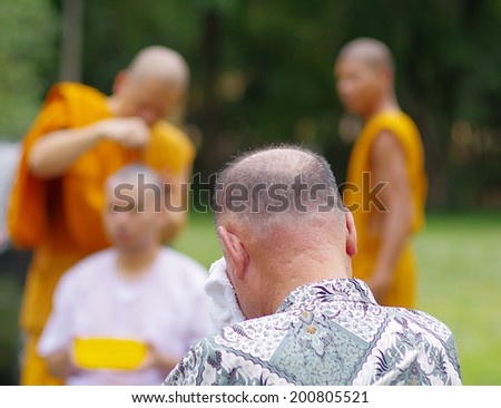 CHONBURI, THAILAND - JUNE 15 : Thai man gets his head shaved by a monk during a Buddhist ordination ceremony on June 15, 2014 in Chonburi, Thailand.