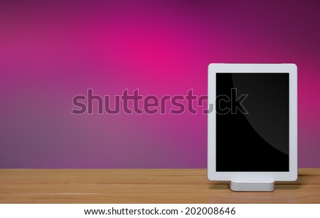 tablet pc computer with dock station on purple color background.
