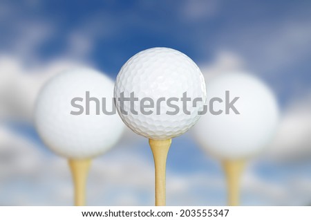 three golf ball on tee, sky blur background