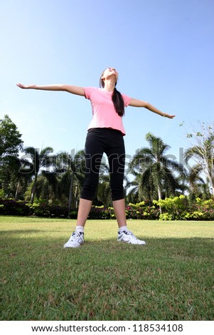 Pretty woman breathing in a park with outdoors exercise