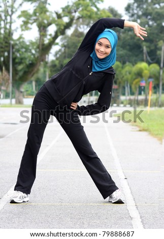 A muslim girl is stretching her body before she jogging.