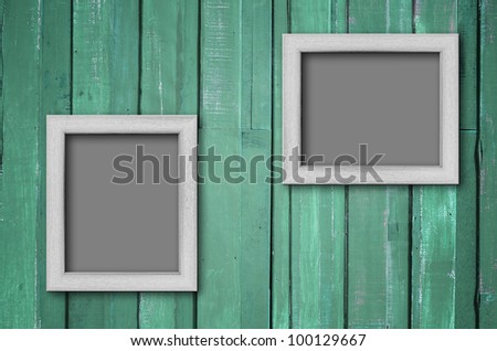 Two white wood picture frame on Green color paint plank wall for background