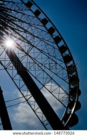 Silhouette Ferris wheel under Sun Light cloud and blue sky