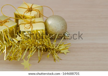 Gold Christmas bauble and Three Present Boxes on Wood Table Background