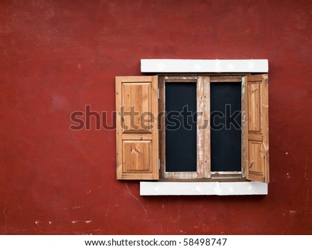open fake wood window on red wall