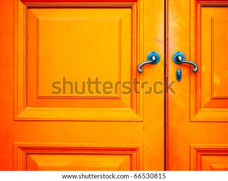Old Blue handle on orange wood door