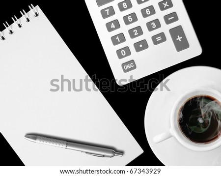White calculator and white note paper with pen and white cup of hot coffee on Black table