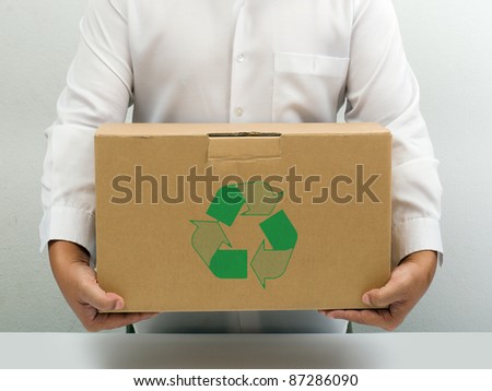 Man in white shirt carry recycle brown paper box hand under