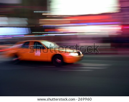A taxicab speeds through New York City\'s Times Square
