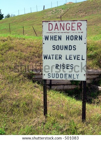 A sign indicates danger on a hill - When Horn Sounds Water Level Rises Suddenly