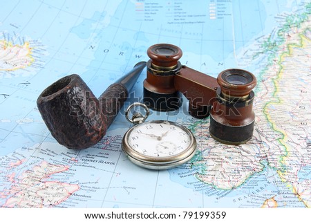 old binoculars, pocket watches and pipe on map of the North Sea