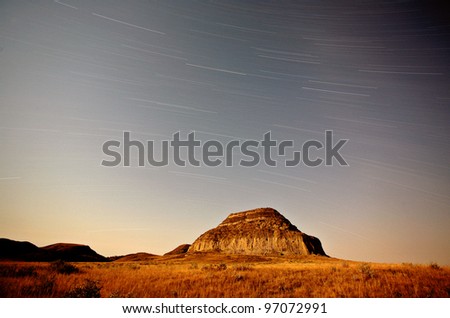 Moon lit Castle Butte and star tracks in scenic Saskatchewan