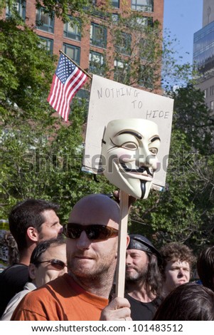 NEW YORK - MAY 1: A man holds a sign with a mask and flag on it that reads \'Nothing To Hide\' during May Day protests in Union Square on May 1, 2012 in New York, NY.