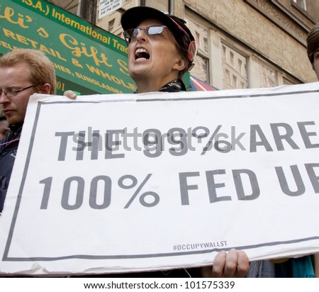 NEW YORK - MAY 1: A protester holds a sign that reads \'The 99% Are 100% Fed Up \' during the march to Union Square from Bryant Park at Occupy Wall St \'May Day\' protests on May 1, 2012 in New York, NY.