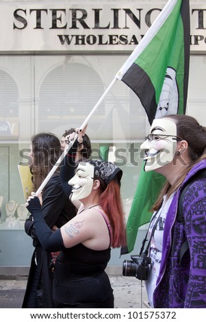 NEW YORK - MAY 1: A protester wearing a Guy Fawkes mask carries a flag during the march to Union Square from Bryant Park at Occupy Wall St \'May Day\' protests on May 1, 2012 in New York, NY.