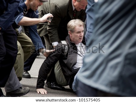 NEW YORK - MAY 1: A dazed man is helped to his feet after police attempt to guide protesters onto sidewalks during the march to Union Square during \'May Day\' protests on May 1, 2012 in New York, NY.