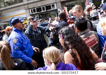 NEW YORK - MAY 1: Police attempt to guide angry protesters onto the sidewalk during the march to Union Square from Bryant Park during Occupy Wall St \'May Day\' protests on May 1, 2012 in New York, NY.