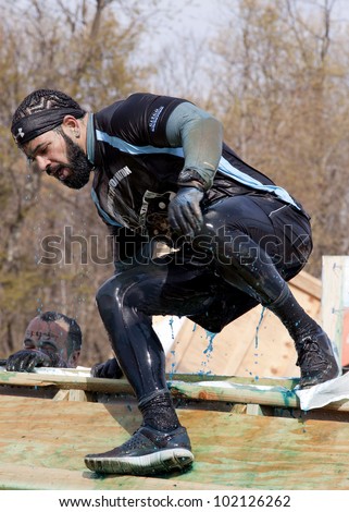 POCONO MANOR, PA - APR 28: A man emerges from a tank filled with water and ice at Tough Mudder on April 28, 2012 in Pocono Manor, PA. The course is designed by British Special Forces.