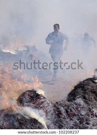 POCONO MANOR, PA - APR 28: A man runs through the Fire Walker obstacle at Tough Mudder on April 28, 2012 in Pocono Manor, Pennsylvania. The course is designed by British Royal troops.